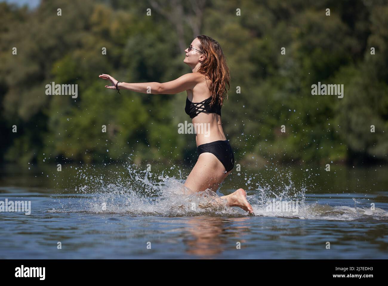 Mädchen am Strand läuft ins Wasser Stockfoto