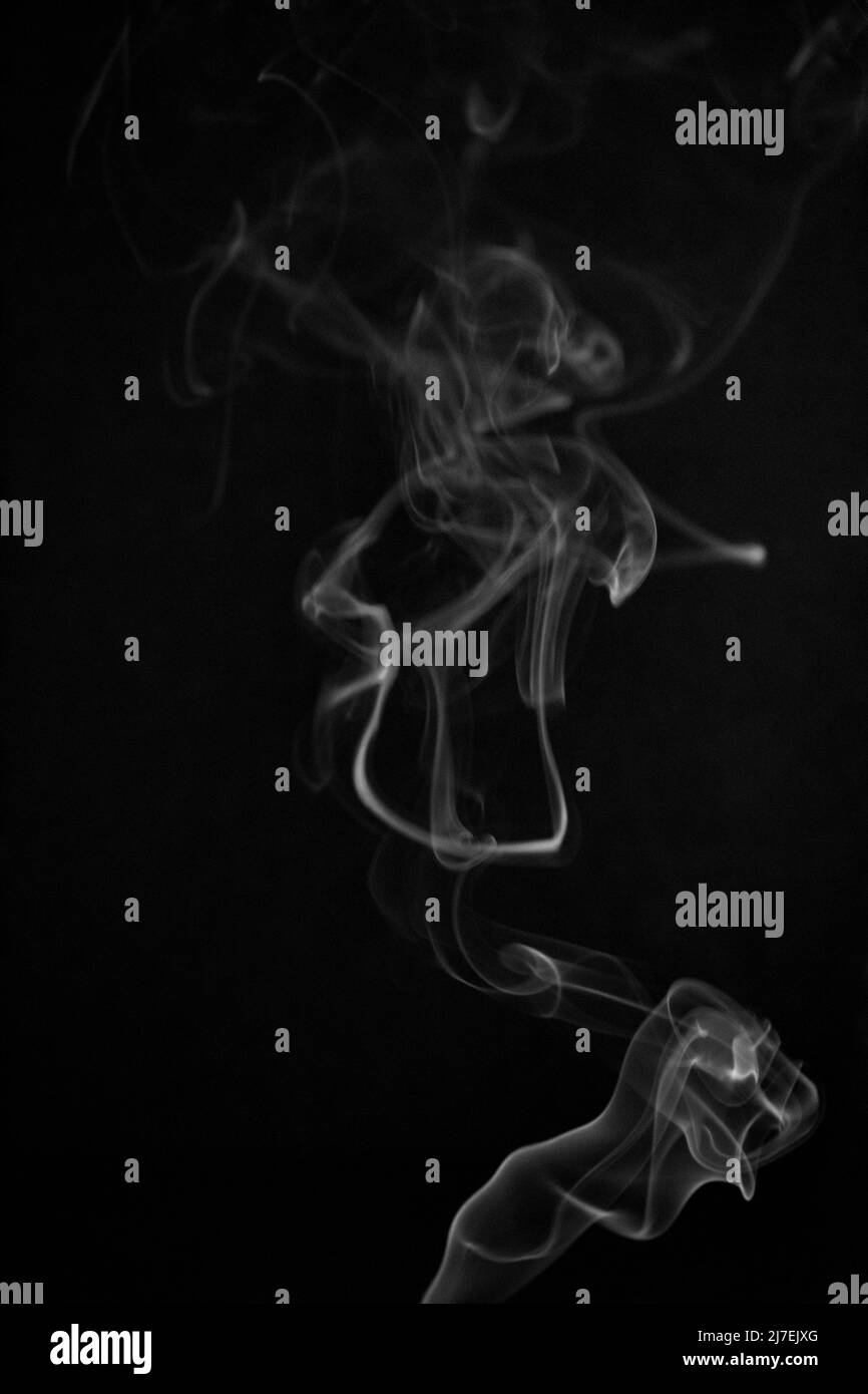 Schwarz-weiß wirbelndes, aufsteigendes Rauchmuster auf schwarzem Hintergrund, Foto könnte als Hintergrund, Rauchstruktur, abstrakt oder allgemeiner Stoc verwendet werden Stockfoto