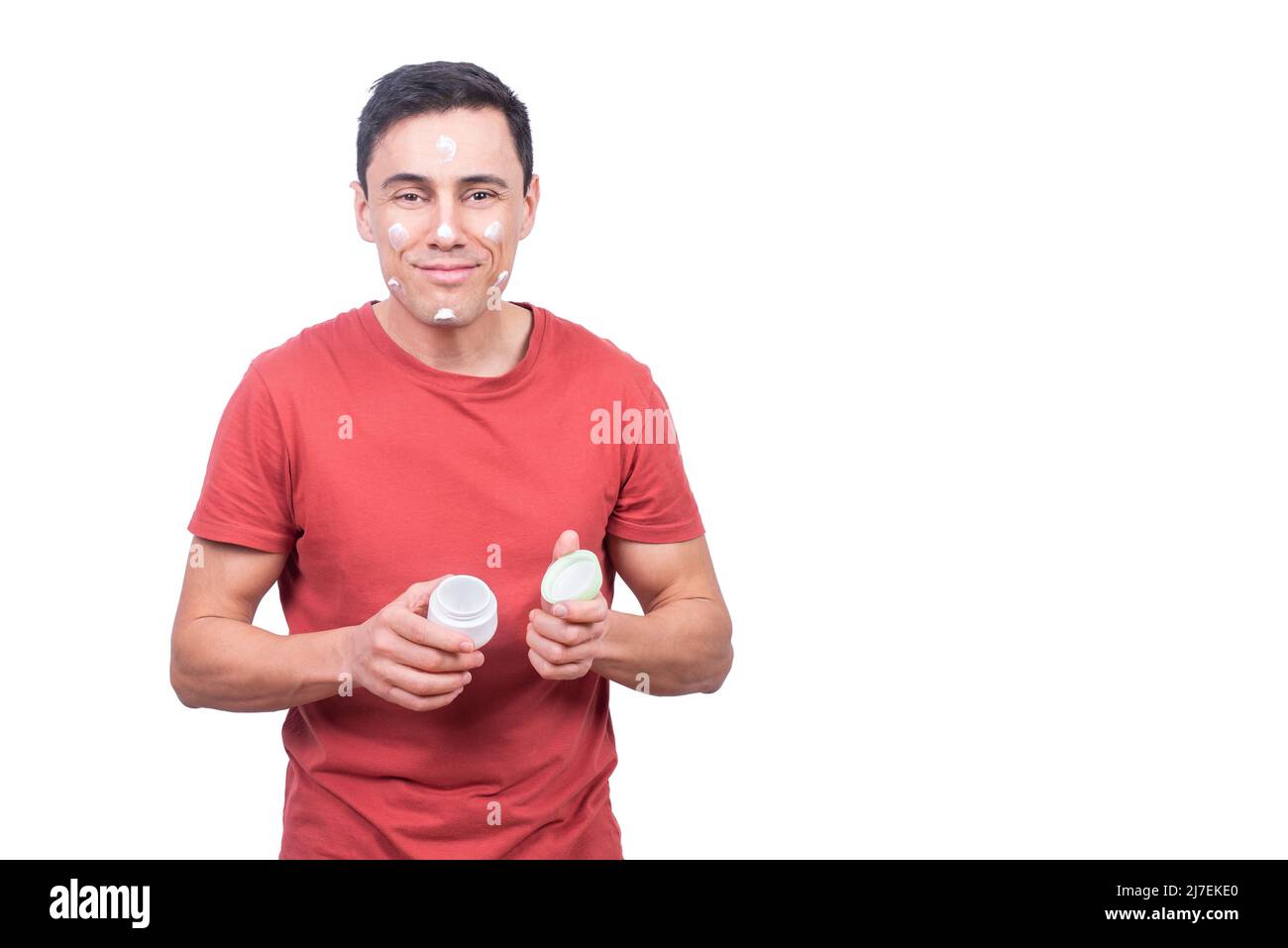Fröhlicher Mann mit Gesichtscreme im Studio Stockfoto