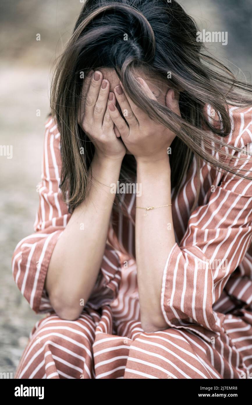 Gestresste Frau, Kopf in den Händen, weinend Stockfoto