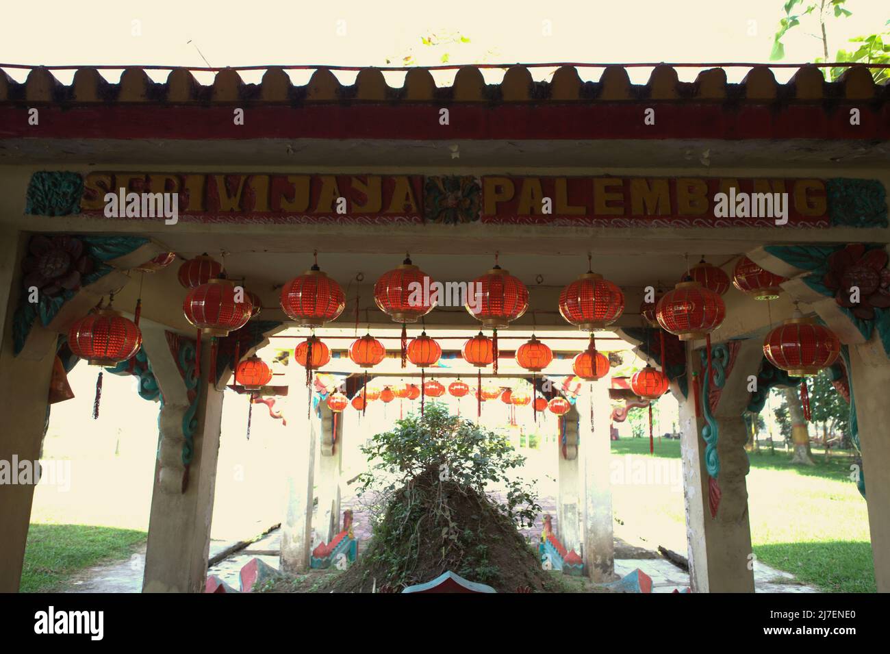 Eine Dachkonstruktion mit einem schriftlichen Schild, auf dem „Seriwijaya (Srivijaya) Palembang“ steht, an einem alten Grab im Tempelkomplex Pulo Kemaro (Kemaro-Insel) – einem Verehrungsort für Buddhismus, Taoismus und Konfuzianismus in Palembang, Südsumatra, Indonesien. Laut einer lokalen Folklore gehörte das Grab der Prinzessin von Srivijaya. Stockfoto