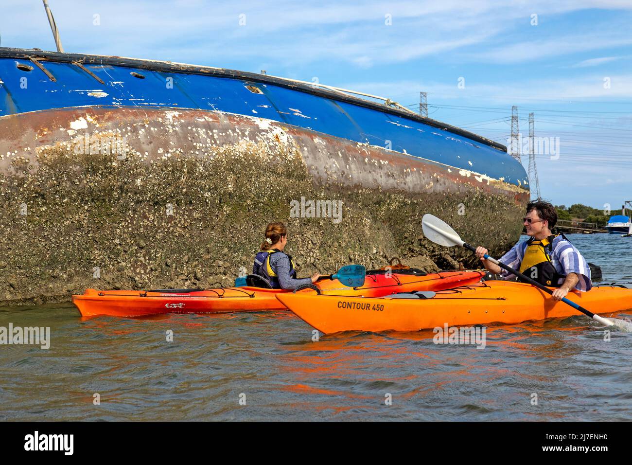 Kajakfahren an einer zerstörten Yacht im Port River vorbei Stockfoto
