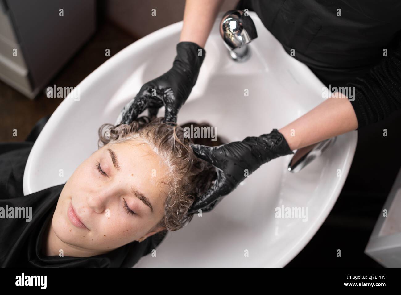 Schöne Dame entspannen und fühlen sich wohl beim Waschen der Haare mit Shampoo und Massage. Friseursalon Studio mit stilvollen Frisur, Schönheit und Mode Stockfoto