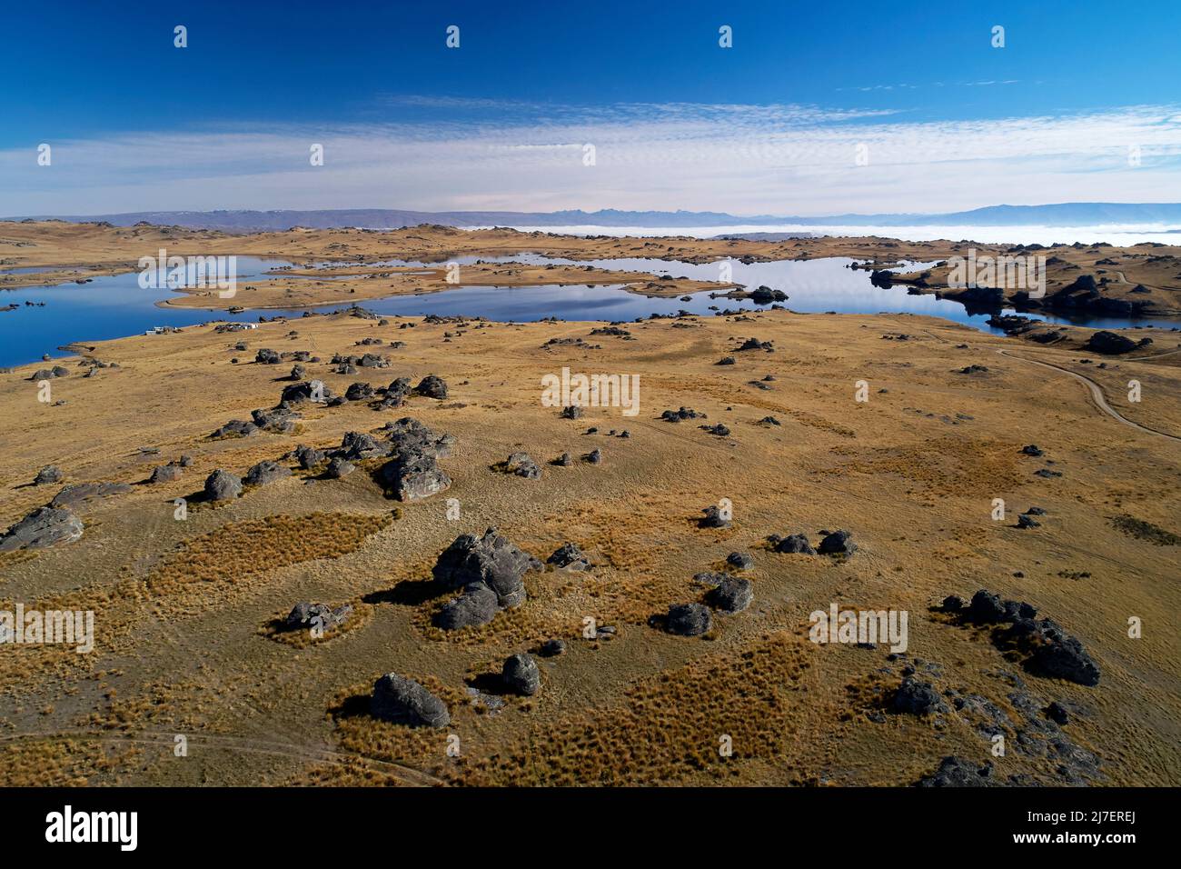 Felsige Landschaft und Poolburn Dam, Central Otago, South Island, Neuseeland - Drohnenantenne Stockfoto