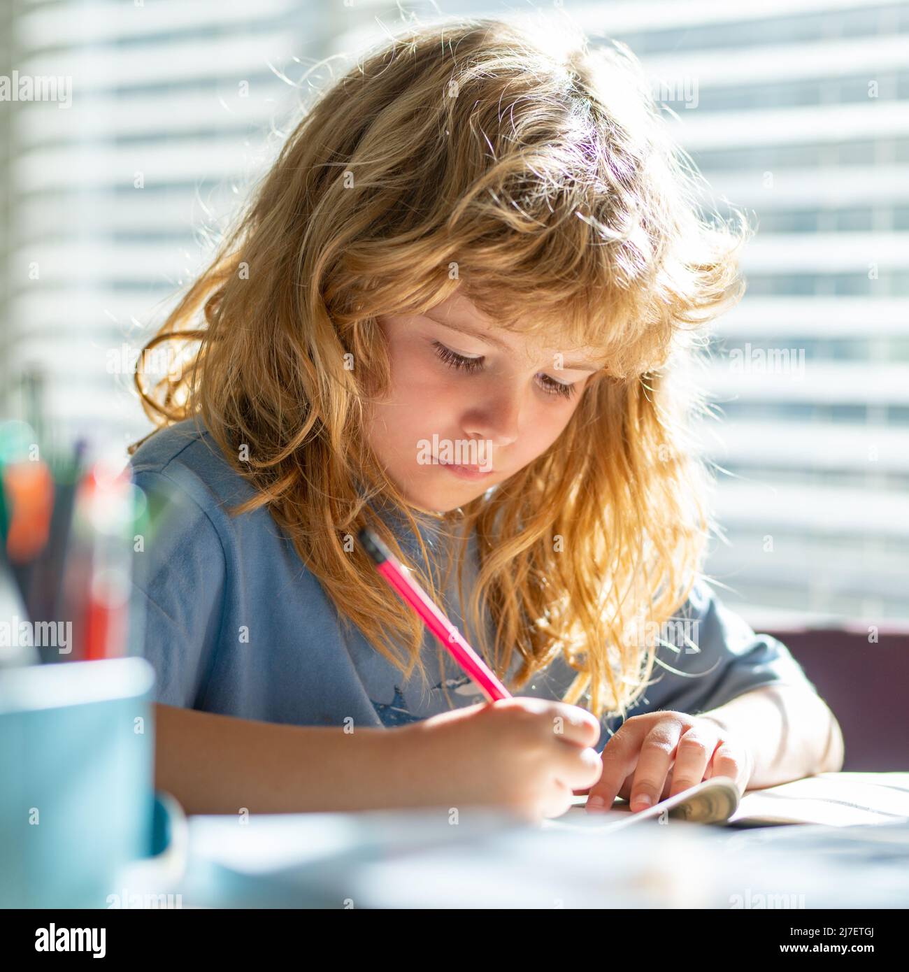 Kind schreibt Hausaufgaben in der Schulklasse. Präteen Schuljunge tun ihre Hausaufgaben zu Hause. Kinderstudie. Bildung und Lernen für Kinder. Netter kleiner Junge Stockfoto