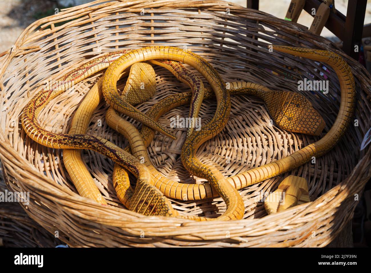 Holzkobras in einem Korb. Souvenirs. Ausflüge Stockfoto