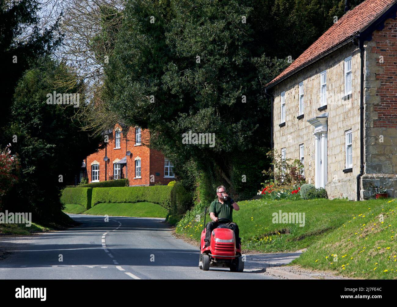 Mann und Aufsitzmäher im Dorf Warter, East Yorkshire, England Stockfoto