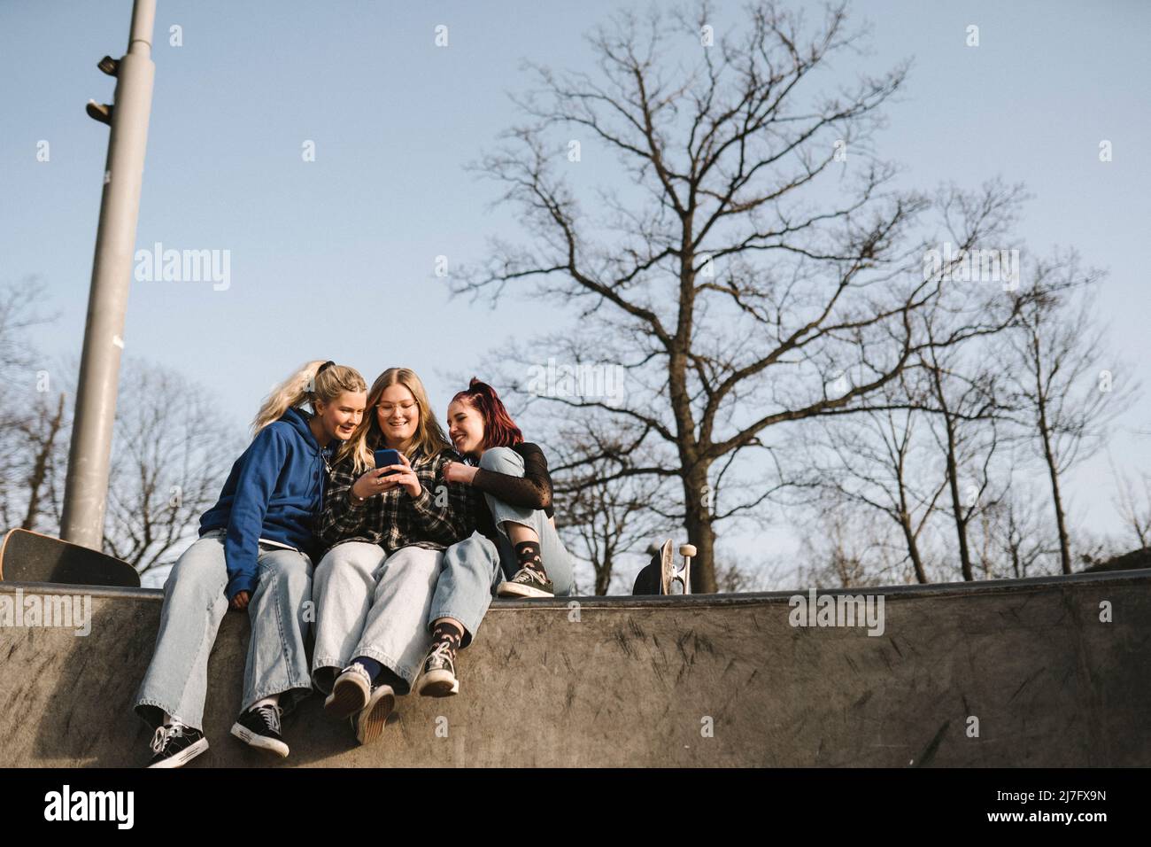 Teenager-Mädchen mit Telefon im Skatepark Stockfoto