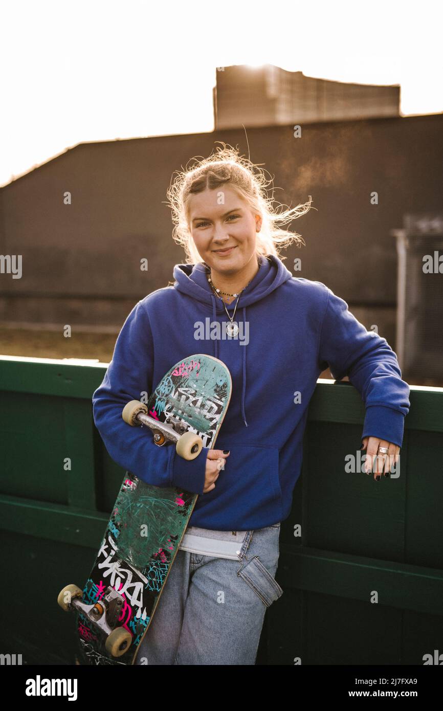 Porträt eines lächelnden Teenagers mit Skateboard Stockfoto