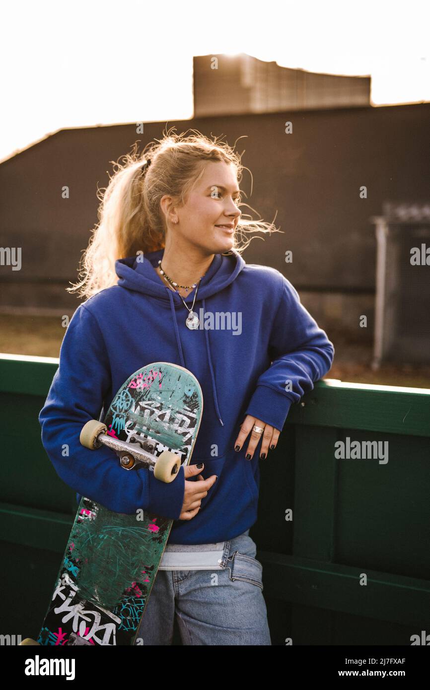 Lächelndes Teenager-Mädchen mit Skateboard Stockfoto