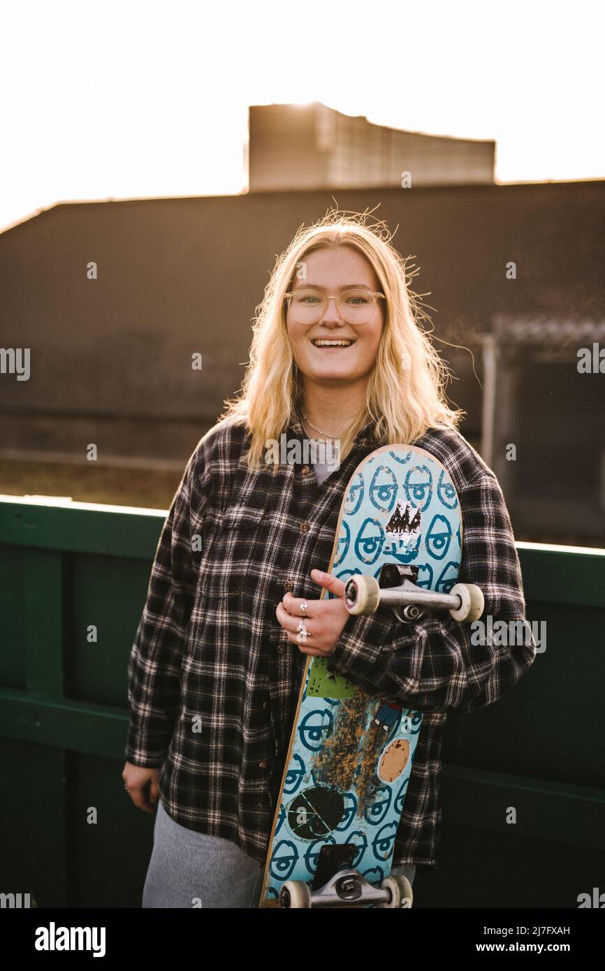 Porträt eines lächelnden Teenagers mit Skateboard Stockfoto