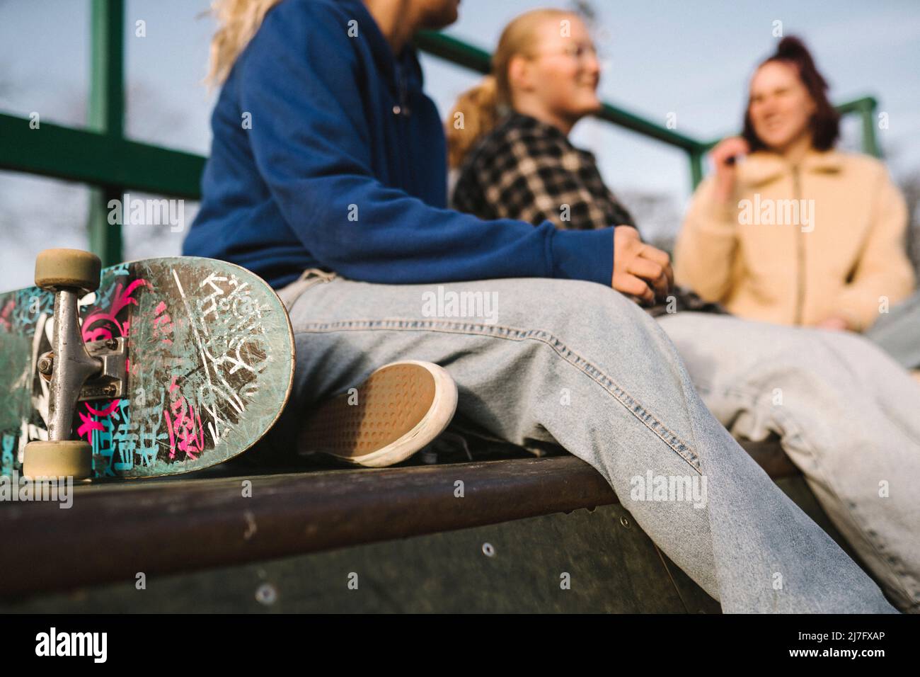 Teenager Mädchen mit Skateboard sitzen im Skatepark Stockfoto