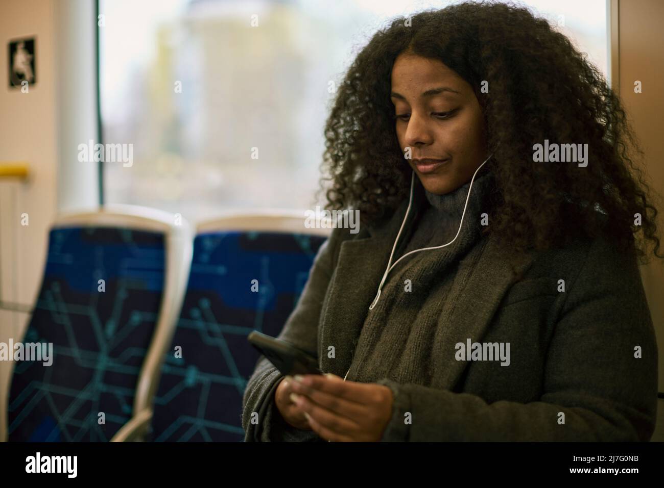 Frau im Zug mit Handy Stockfoto
