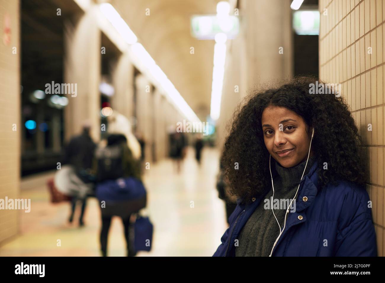 Lächelnde Frau, die am Bahnhof steht Stockfoto