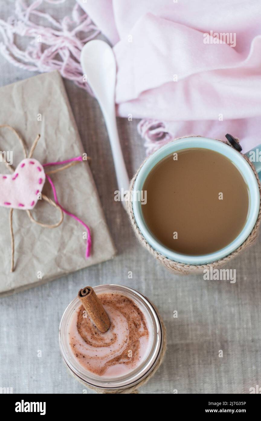 Romantisches reichhaltiges Frühstück: Haferflocken mit Beerenjoghurt und Zimt, Kaffee mit Milch und Vintage-Notizbuch für Rekorde Stockfoto