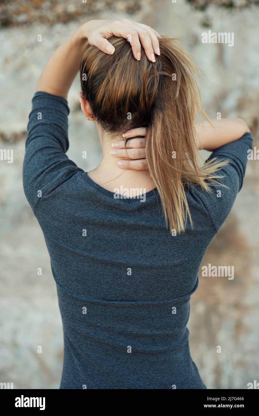 Rückansicht der Hände einer Frau im Haar Stockfoto