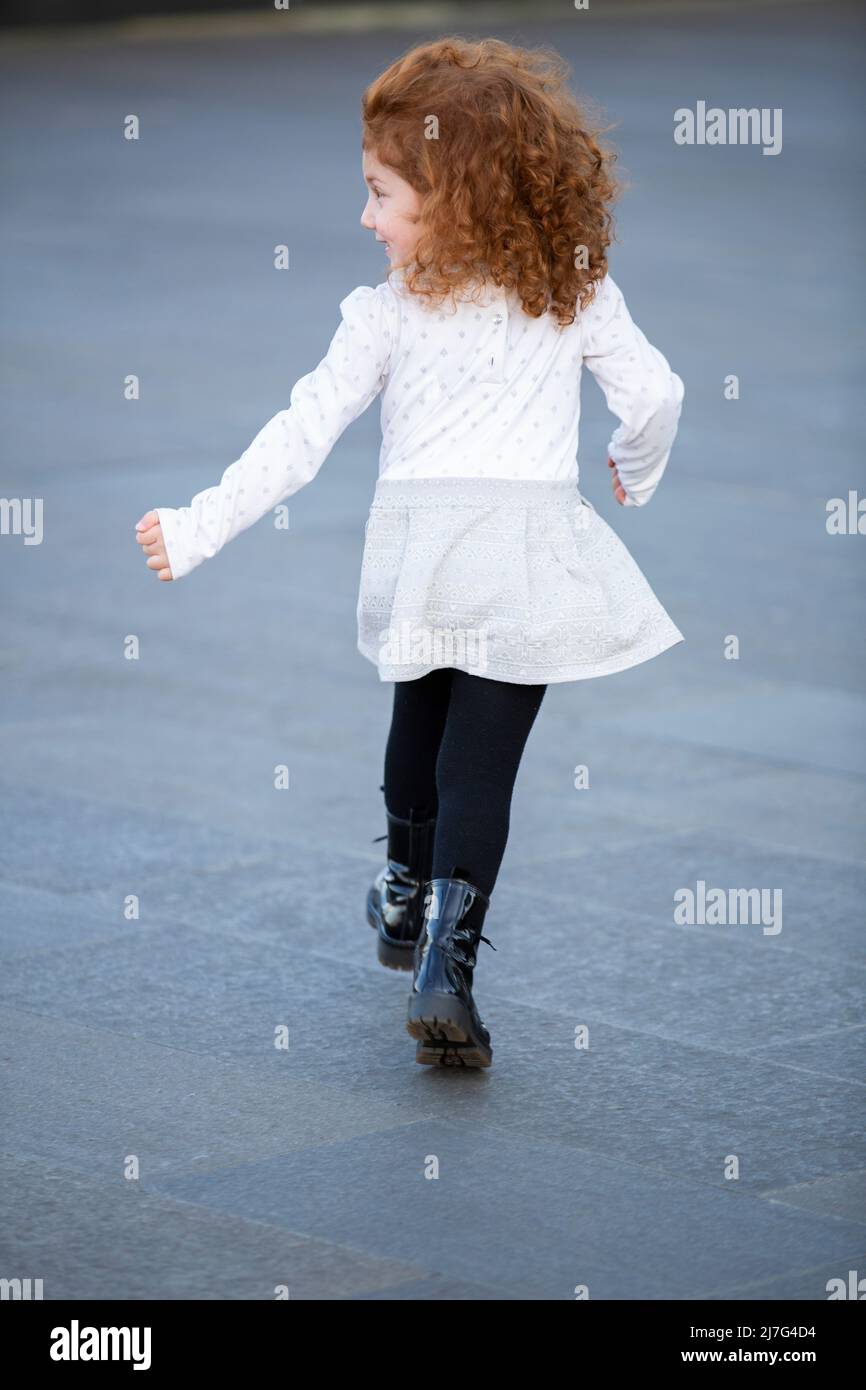 Glückliches kleines Mädchen, das draußen läuft Stockfoto