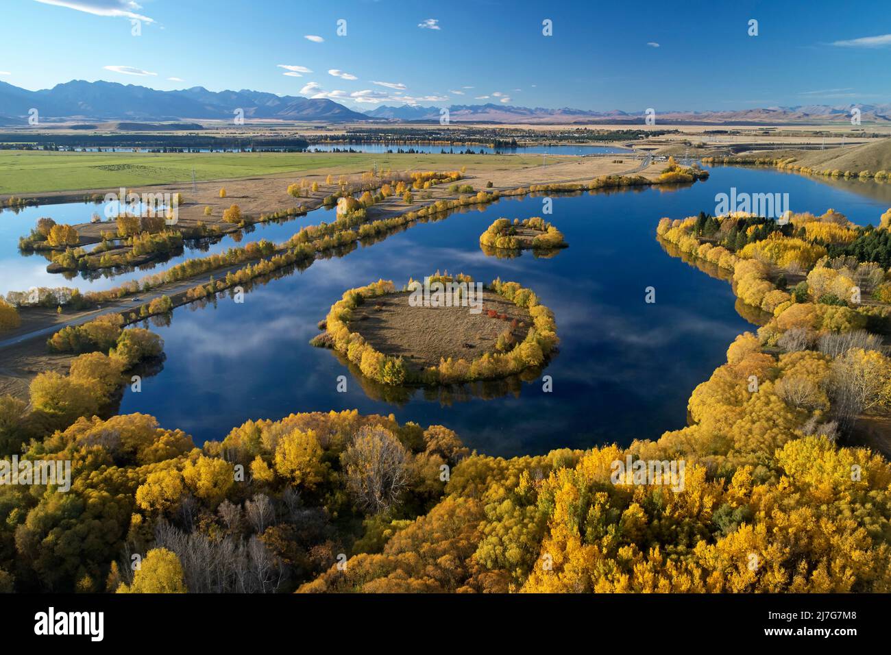 Herbstfarben und Insel in Wairepo Arm, Twizel, Mackenzie District, North Otago, South Island, Neuseeland - Drohnenantenne Stockfoto