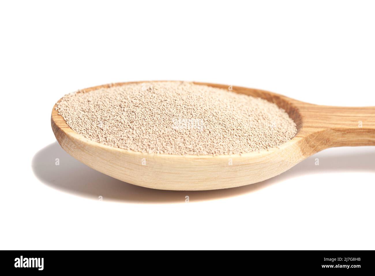 Aktive Trockenbackhefe-Granulat in Holzlöffel. Stockfoto