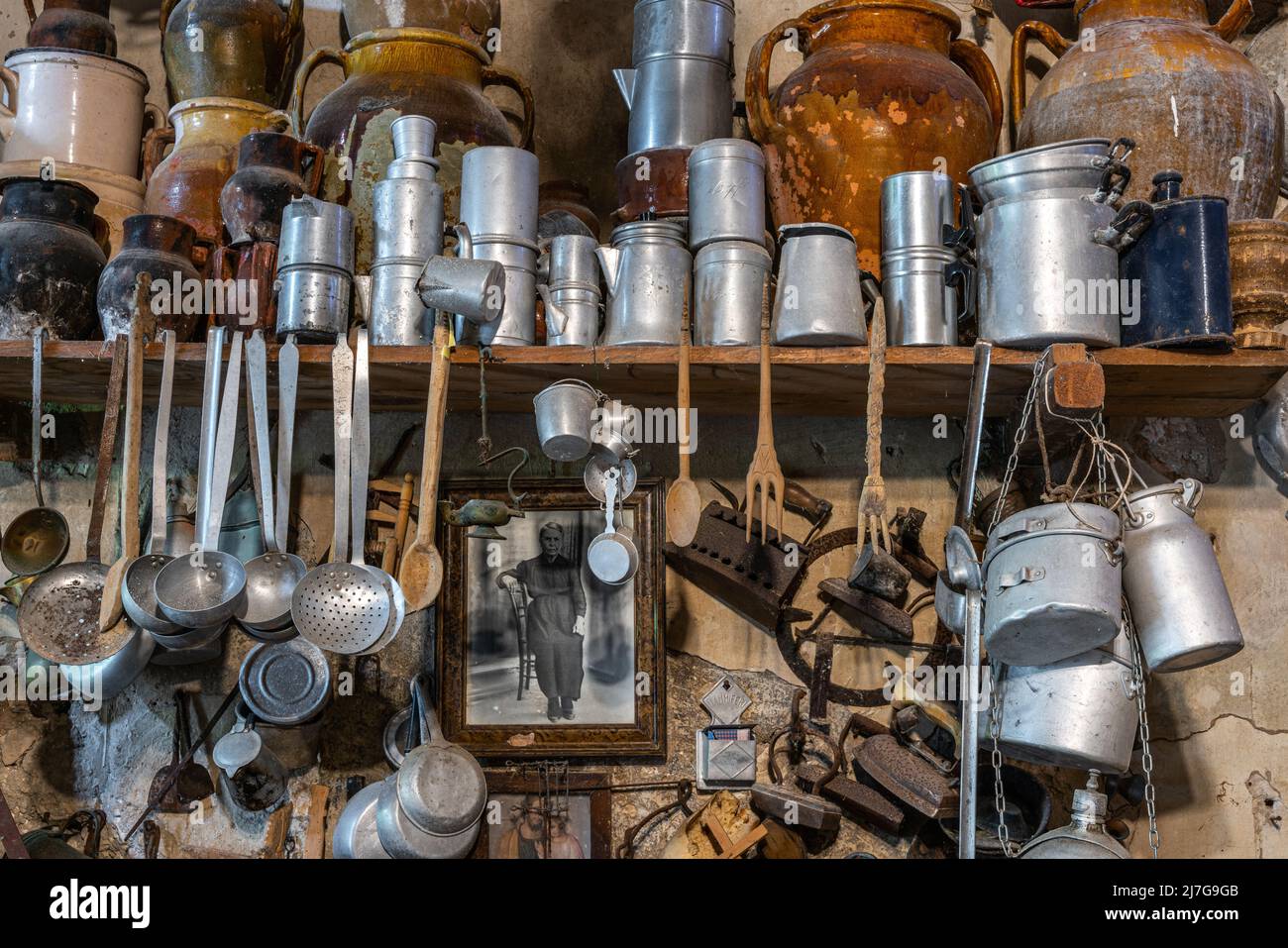 Museumsausstellung von Haushaltsgeräten, Töpfen, Pfannen, Amphoren und Bügeleisen, antike oder Vintage an der Wand hängen. Peschici, Provinz Foggia, Apulien Stockfoto