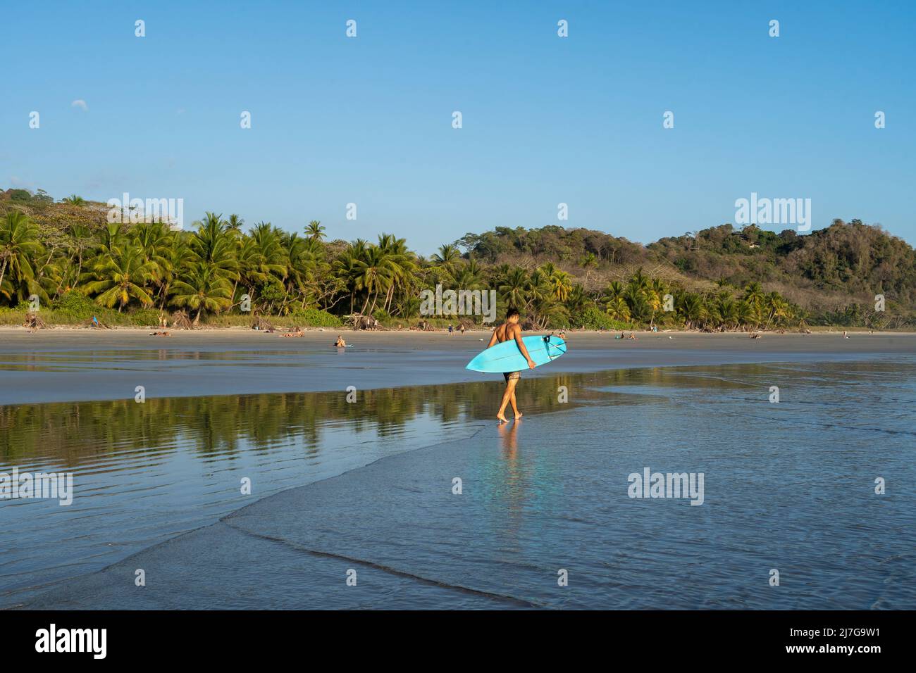 Surfer zu Fuß am Strand an der wunderschönen Playa Hermosa in Santa Tersa, Costa Rica. Stockfoto