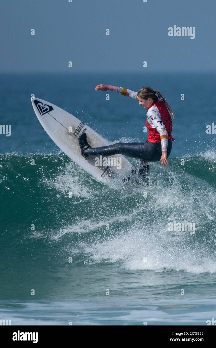 Eine Surferin, die an einem Surfwettbewerb im britischen Fistral in Newquay in Cornwall teilhat. Stockfoto