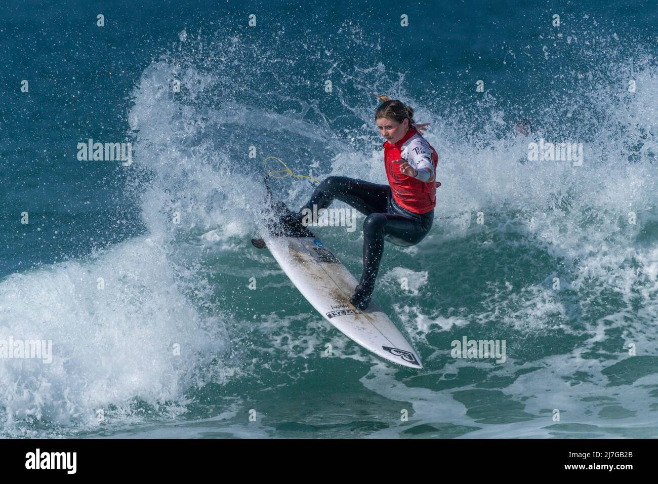 Eine Surferin, die an einem Surfwettbewerb im britischen Fistral in Newquay in Cornwall teilhat. Stockfoto