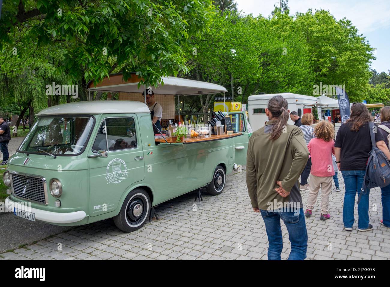 Menschen, die in den Food Vans auf dem Dinosaur Festival in Katerini City, Griechenland, wandern und bestellen Stockfoto