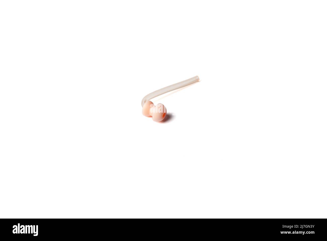 Hörgerätersatz-Ohrmuppel mit Silikonschlauch isoliert auf weißem Hintergrund. Zubehör für Hörgeräte. Stockfoto