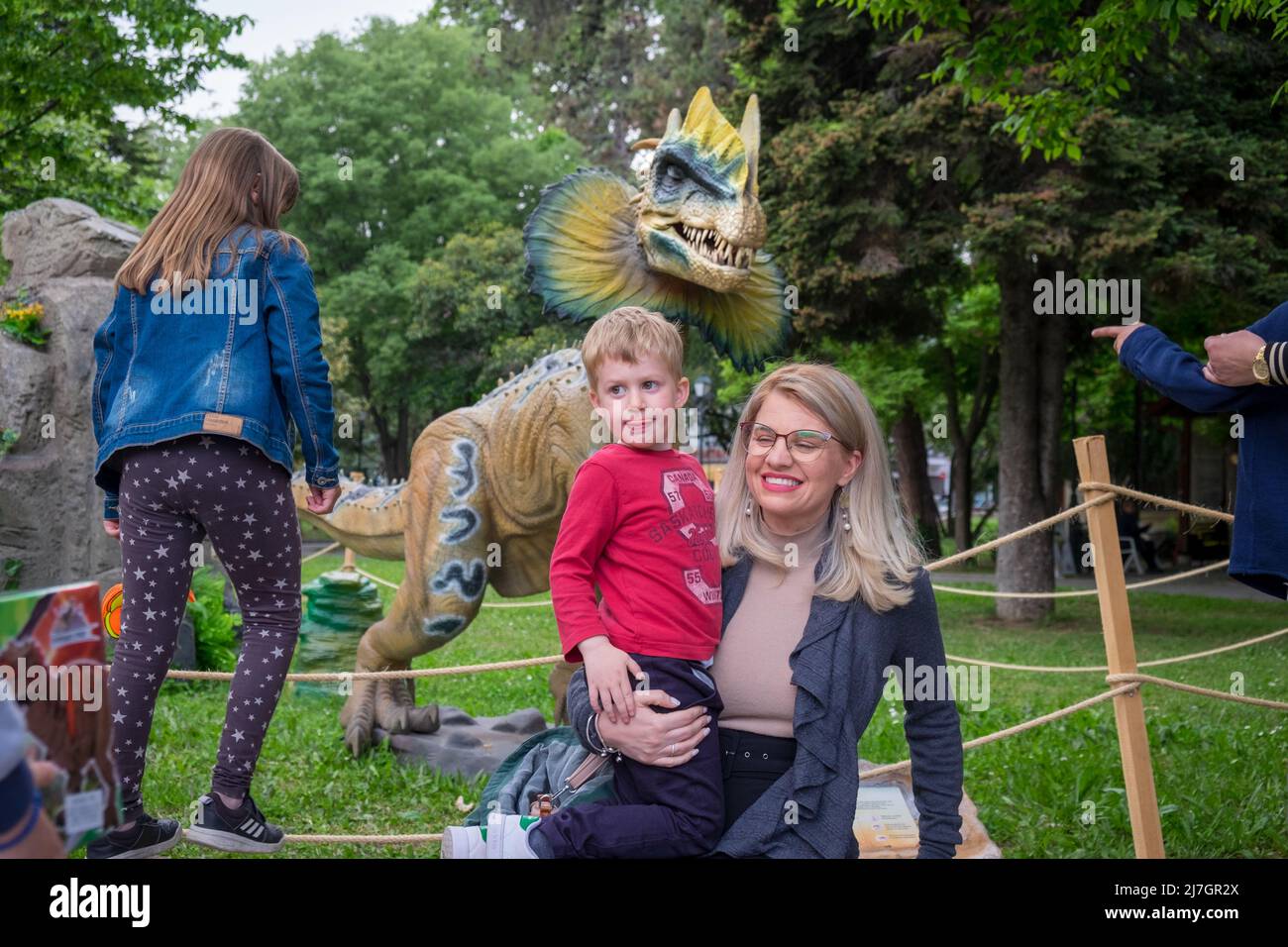 Mutter hält ihren Sohn in den Armen und hat Spaß am Dinosaurierfest. Stockfoto