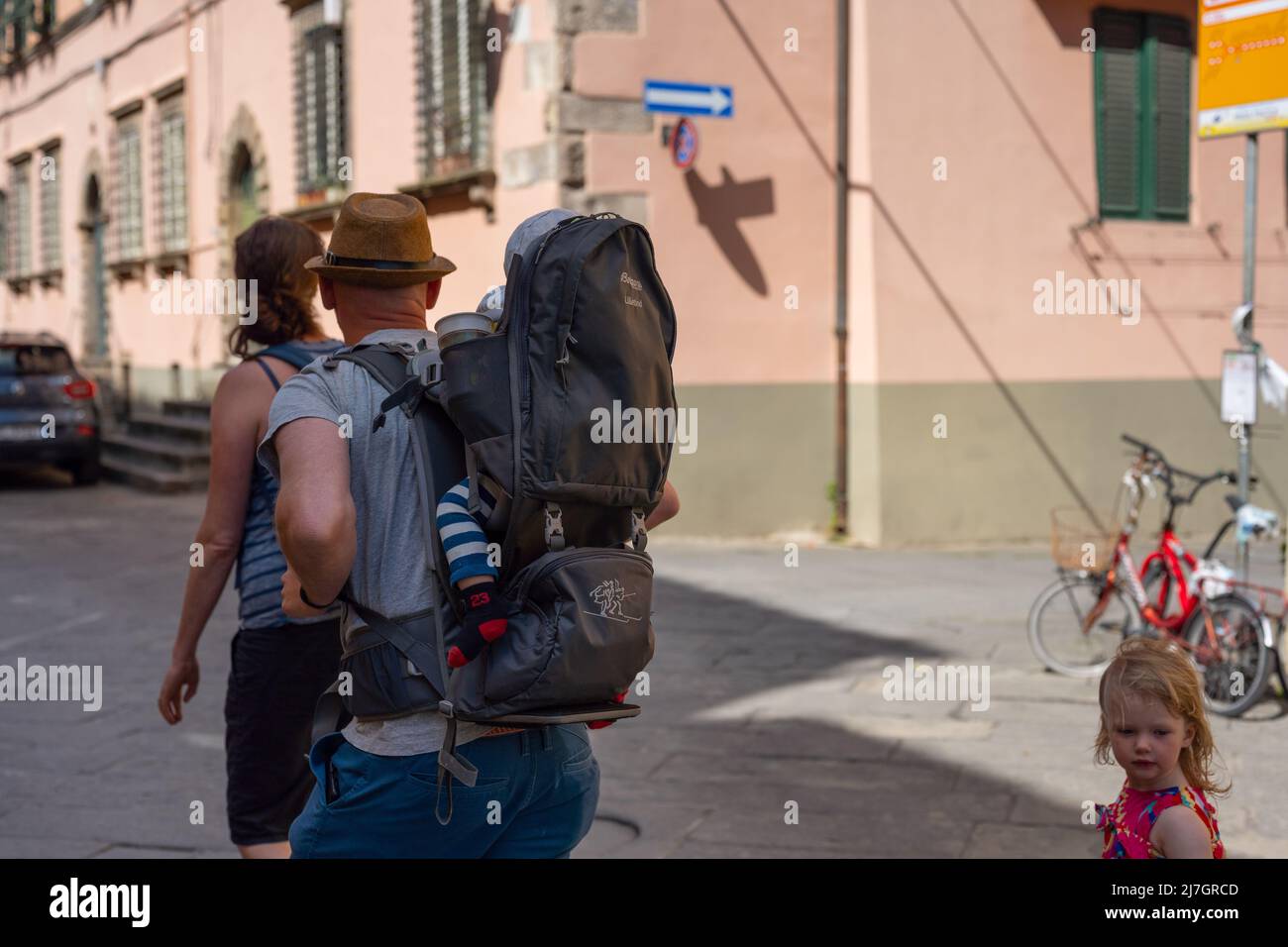 Junge Familie spazieren in einer Seitenstraße von Lucca Stockfoto