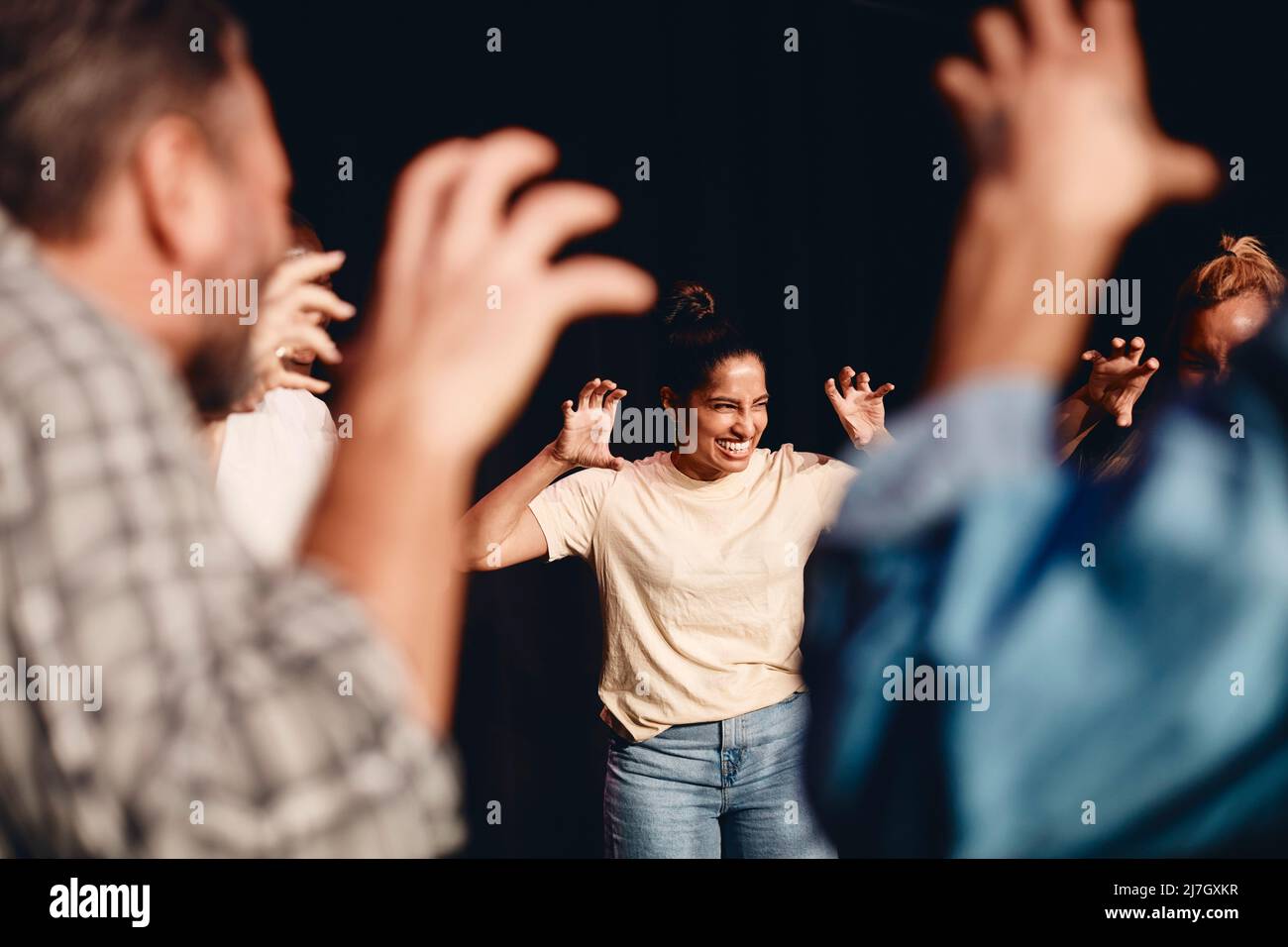 Fröhliche Schauspielerin, die während der Proben mit Bühnendarstellern im Unterricht gestikuliert Stockfoto