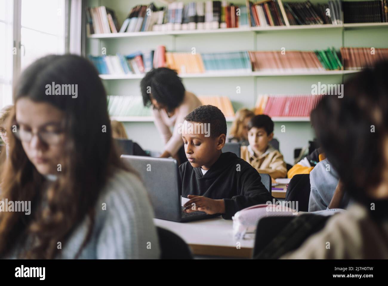Junge mit Laptop beim E-Learning im Klassenzimmer Stockfoto