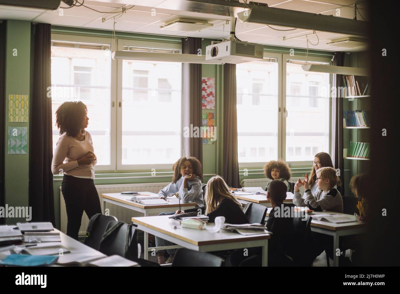 Schüler und Lehrer diskutieren während der Vorlesung im Klassenzimmer Stockfoto