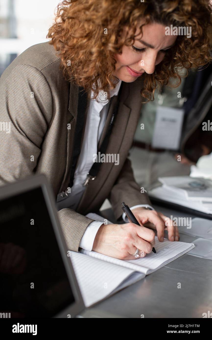 Geschäftsfrau, die sich für das Seminar im Konferenzzentrum anmeldet Stockfoto