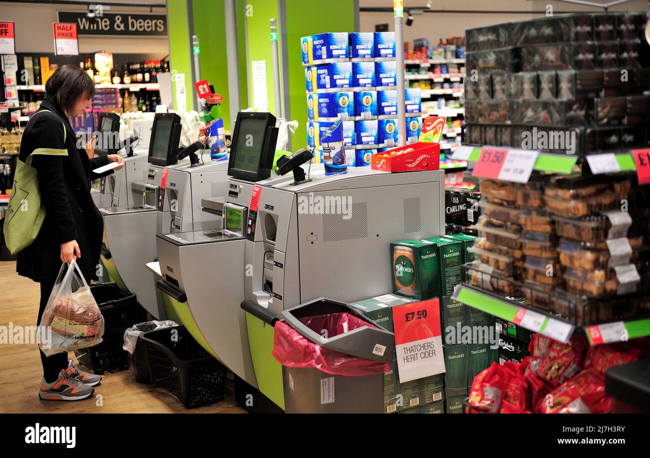 Frau am Supermarkt Selbstbedienungskassen überprüfen Quittung, Großbritannien Stockfoto