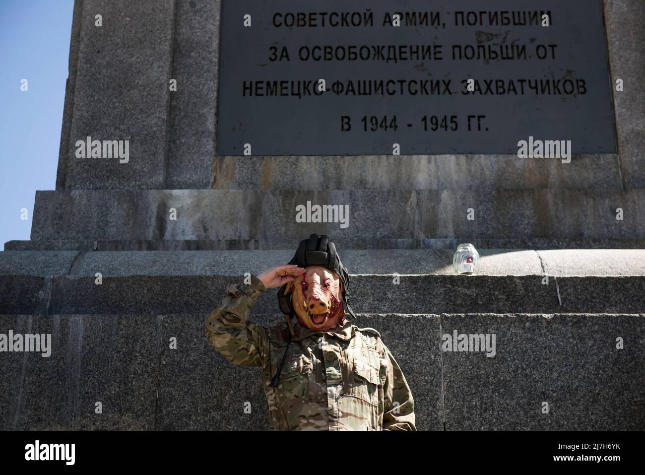 Ein Mann, der als sowjetischer Soldat mit einer Schweinemaske im Gesicht gekleidet ist, grüßt, während er auf dem Denkmal für sowjetische Soldaten steht, die im Zweiten Weltkrieg starben Hunderte von Ukrainern und polnischen Aktivisten protestierten auf einem Warschauer Friedhof vor Soldaten der Roten Armee, die während des Zweiten Weltkriegs starben Der russische Botschafter in Polen, Sergej Andreev, wurde von Demonstranten, die gegen den Krieg in der Ukraine waren, bei einer jährlichen Veranstaltung zum Tag des Sieges zum Gedenken an das Ende des Zweiten Weltkriegs mit roter Farbe angestrichen Botschafter Sergej Andreew kam am Tag des Sieges auf dem sowjetischen Soldatenfriedhof an, um Blumen zu legen, aber der Diplomat und seine Delegation wurden gezwungen Stockfoto