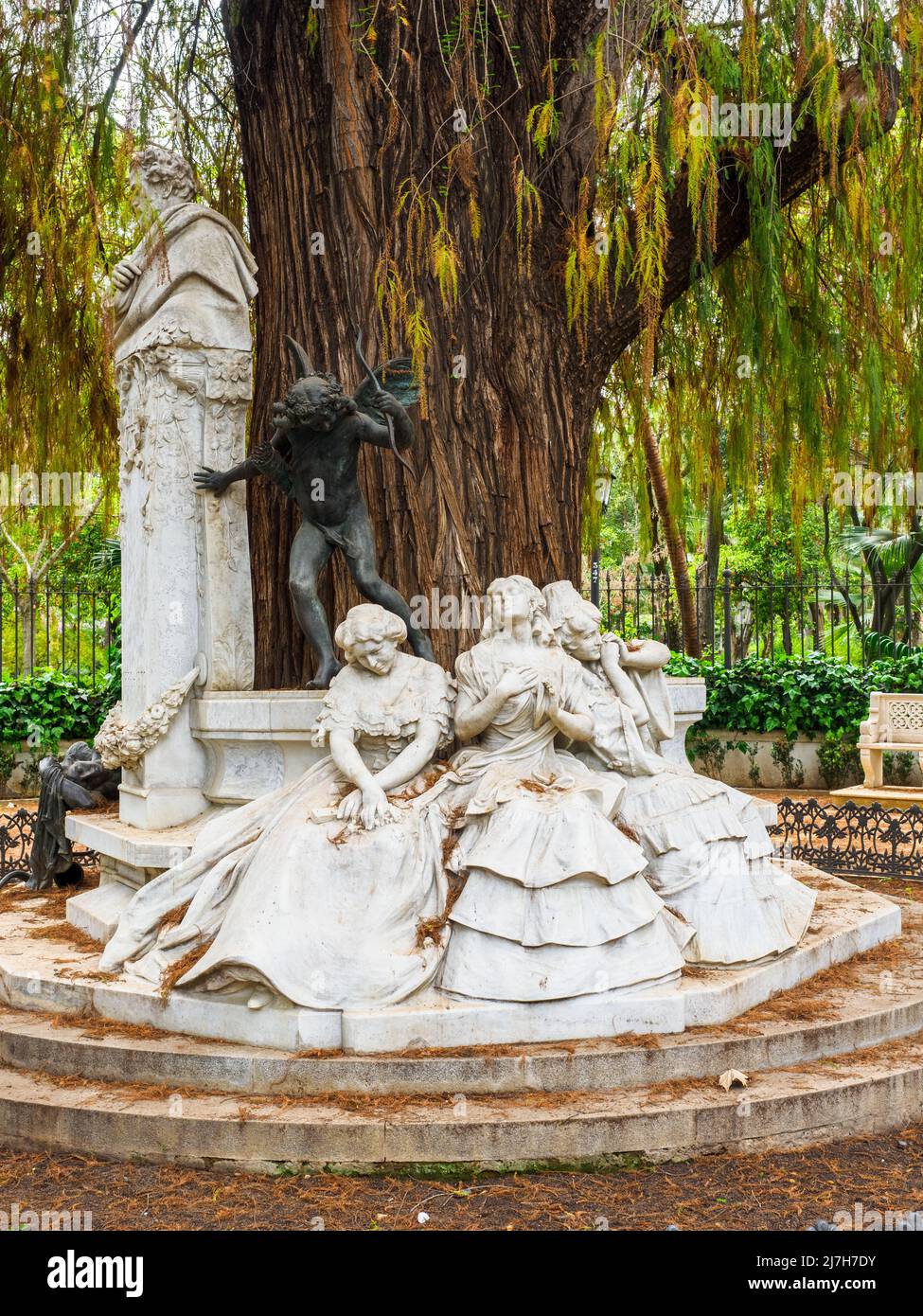 Skulpturale Gruppe von Lorenzo Coullaut Valera im Gustavo Adolfo Bécquer Turnaround. Die Büste des Dichters, drei weibliche Figuren, die auf einer Bank sitzen, die die drei Zustände der Liebe symbolisieren: „Aufgeregte Liebe“, „besessene Liebe“ und „verlorene Liebe“, und die Bronzestatue des Amors, die „die Liebe, die schmerzt – Park Maria Luisa – Sevilla, Spanien Stockfoto