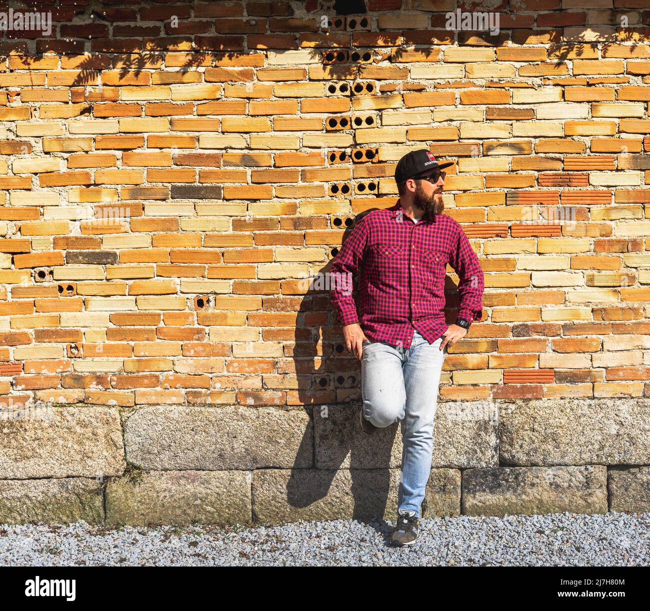 hombre con barba apoyado en la pared Stockfoto