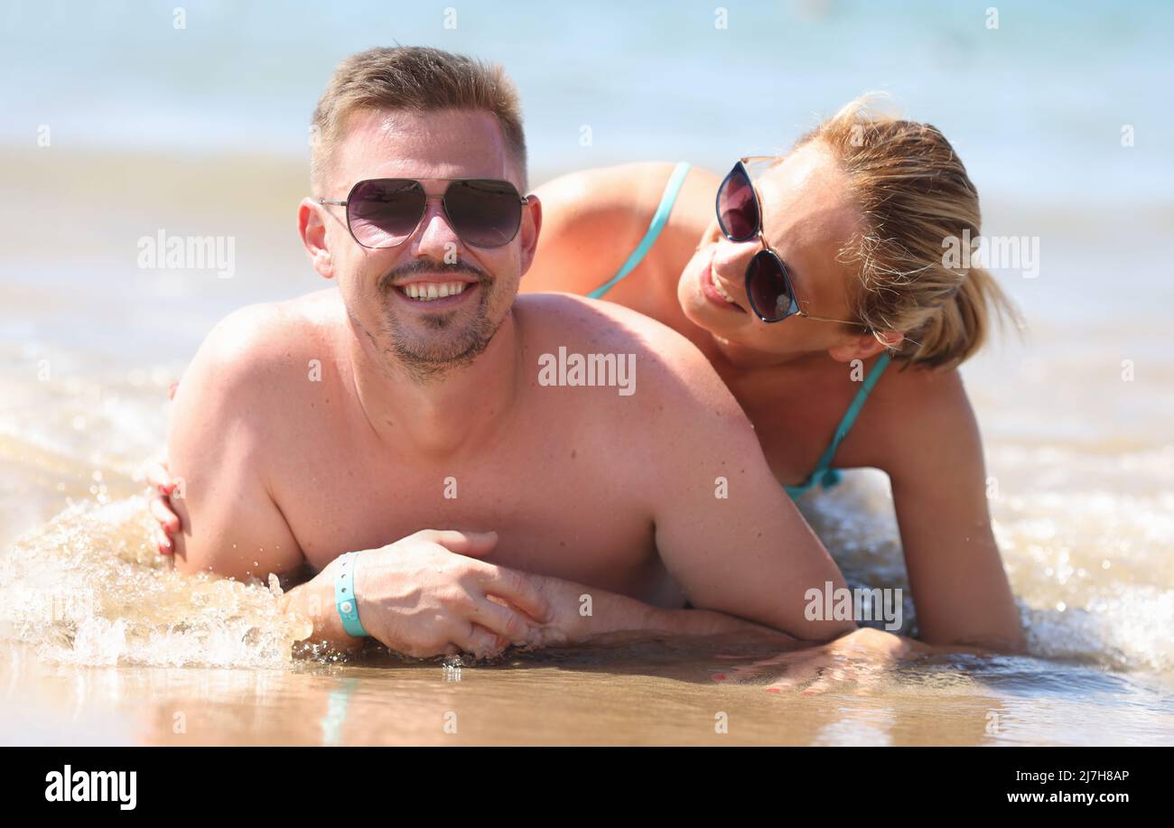 Lächelndes Paar liegt an der Küste und posiert für ein unvergessliches Bild aus dem Urlaub Stockfoto