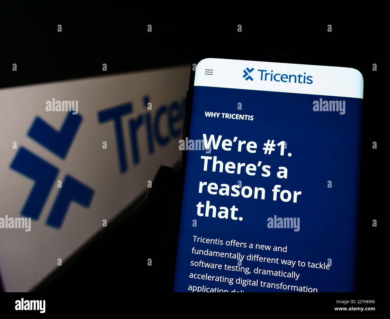 Person, die Smartphone mit der Webseite des österreichischen Softwareunternehmens Tricentis GmbH auf dem Bildschirm vor dem Logo hält. Konzentrieren Sie sich auf die Mitte des Telefondisplays. Stockfoto