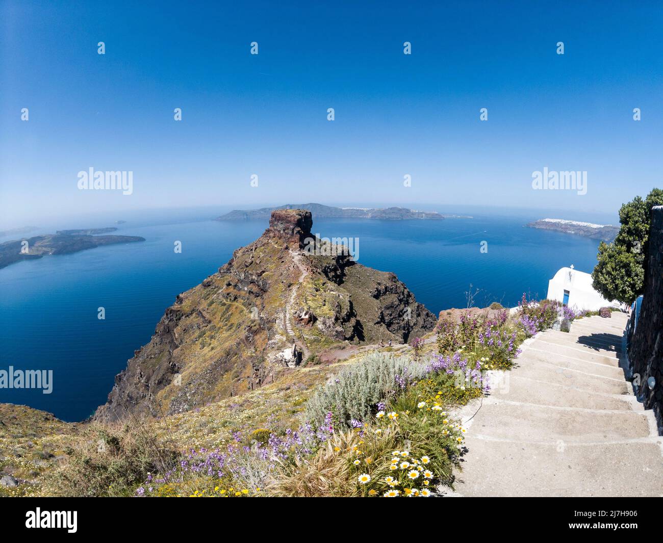 Wunderschöne Aussicht auf den Felshügel von Skaros, auf der Insel Santorini, Griechenland, und Meerblick auf den vulkanischen Teil von Santorini und die legendäre Caldera. Stockfoto