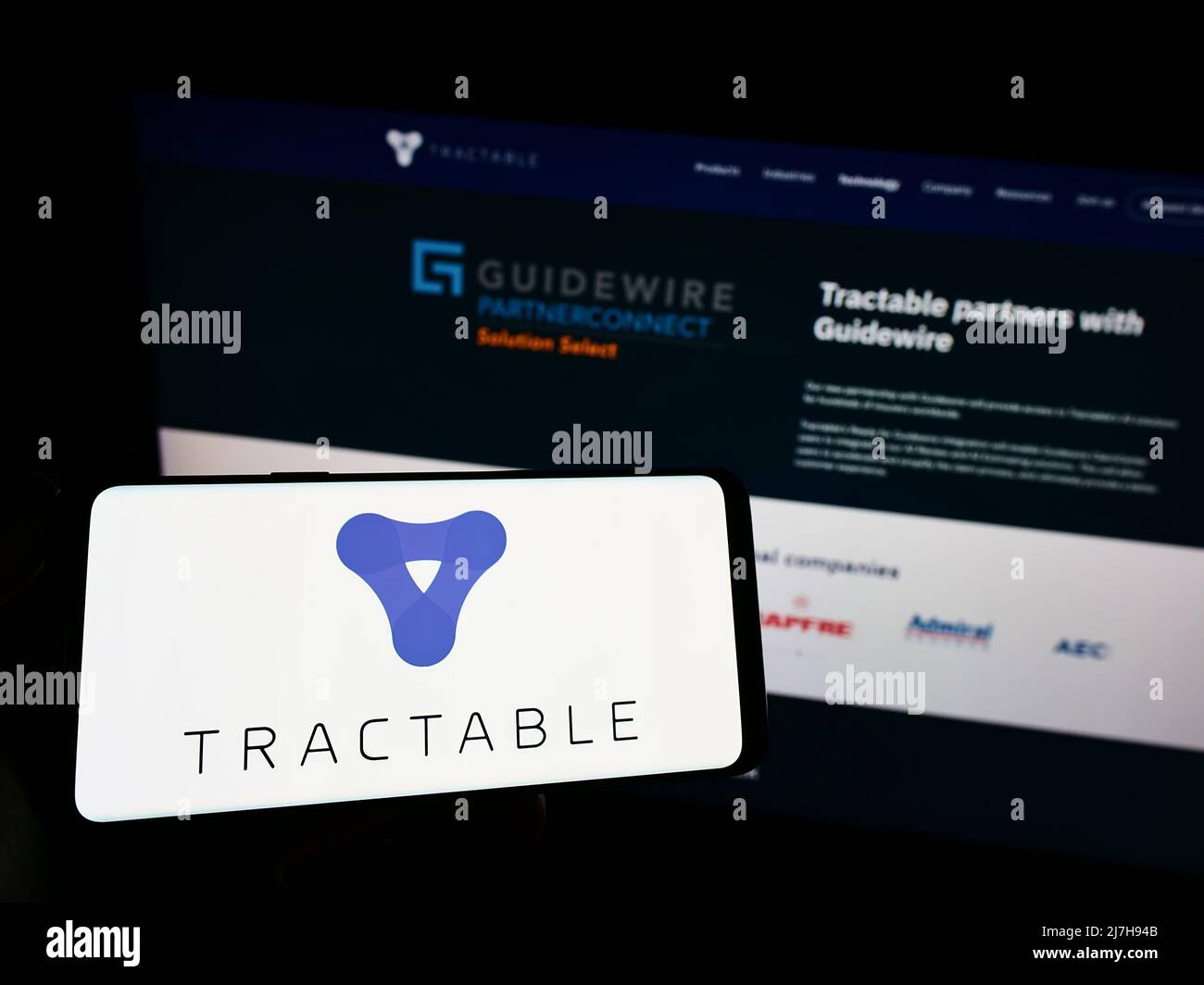 Person hält Smartphone mit Logo der Firma Tractable Ltd. Künstliche Intelligenz auf dem Bildschirm vor der Website. Konzentrieren Sie sich auf die Telefonanzeige. Stockfoto