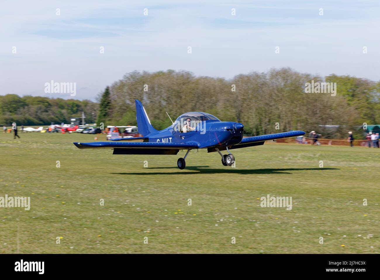 Das smarte blaue Eurostar EV-97-Ultraleichtflugzeug G-NILT kommt auf dem Flugplatz Popham in Hampshire England an, um an der jährlichen Einflugmöglichkeit für Ultraleichtflugzeuge teilzunehmen Stockfoto