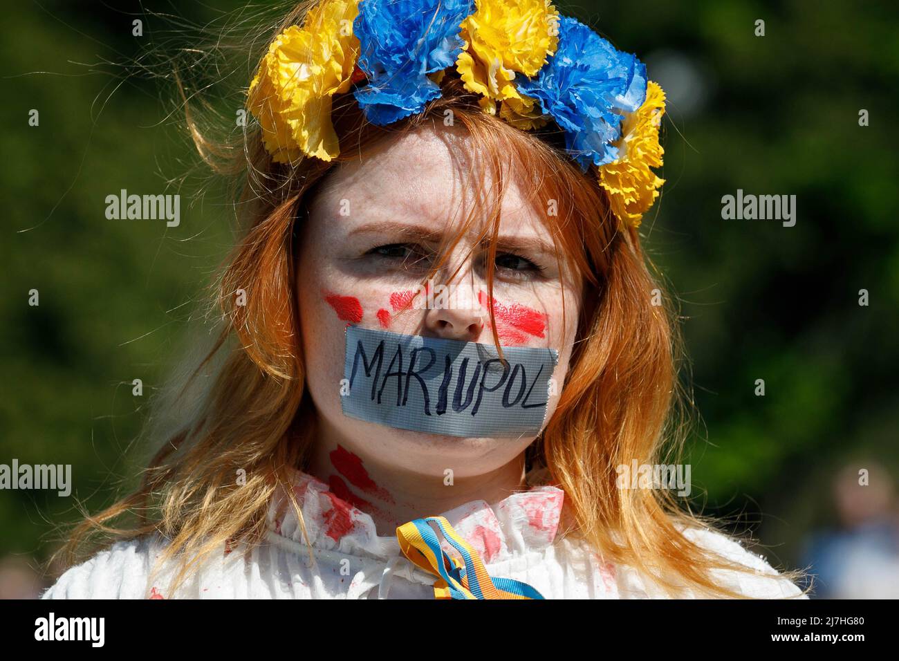 Warschau, Polen. 09.. Mai 2022. Ein Protestler mit mit Klebeband versiegelten Lippen nimmt an dem Protest Teil. Am 77.. Jahrestag des Sieges der Roten Armee über Nazi-Deutschland traten ukrainische Aktivisten auf dem sowjetischen Soldatenfriedhof in Warschau auf, als sie gegen die russische Invasion in der Ukraine protestierten. Aktivisten verboten der russischen Delegation unter der Leitung von Sergej Andreev, dem Botschafter der Russischen Föderation in Polen, den Eintritt in den Friedhof. Während dieses Versuchs wurden Diplomaten von ukrainischen Aktivisten mit gefälschtem Blut übergossen. Kredit: SOPA Images Limited/Alamy Live Nachrichten Stockfoto
