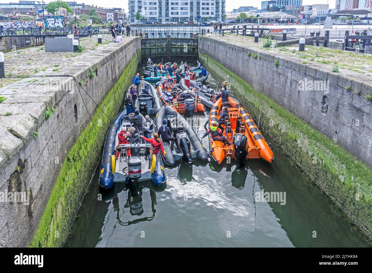 Eine Gruppe von kleinen Booten in der Buckingham Lock, in Ringsend in Dublin, Irland, warten darauf, dass sich die Schleuse füllt und sie durch das Schleusentor fahren lassen, Stockfoto