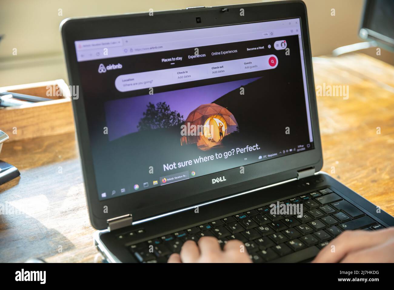 Griechenland, Athen, Januar 23 2022. AIRBNB Home Search, Online-Buchung von Unterkünften App. Kurzfristige Unterkunft mieten auf Computer-Bildschirm. Männliche Hand auf Laptop Stockfoto