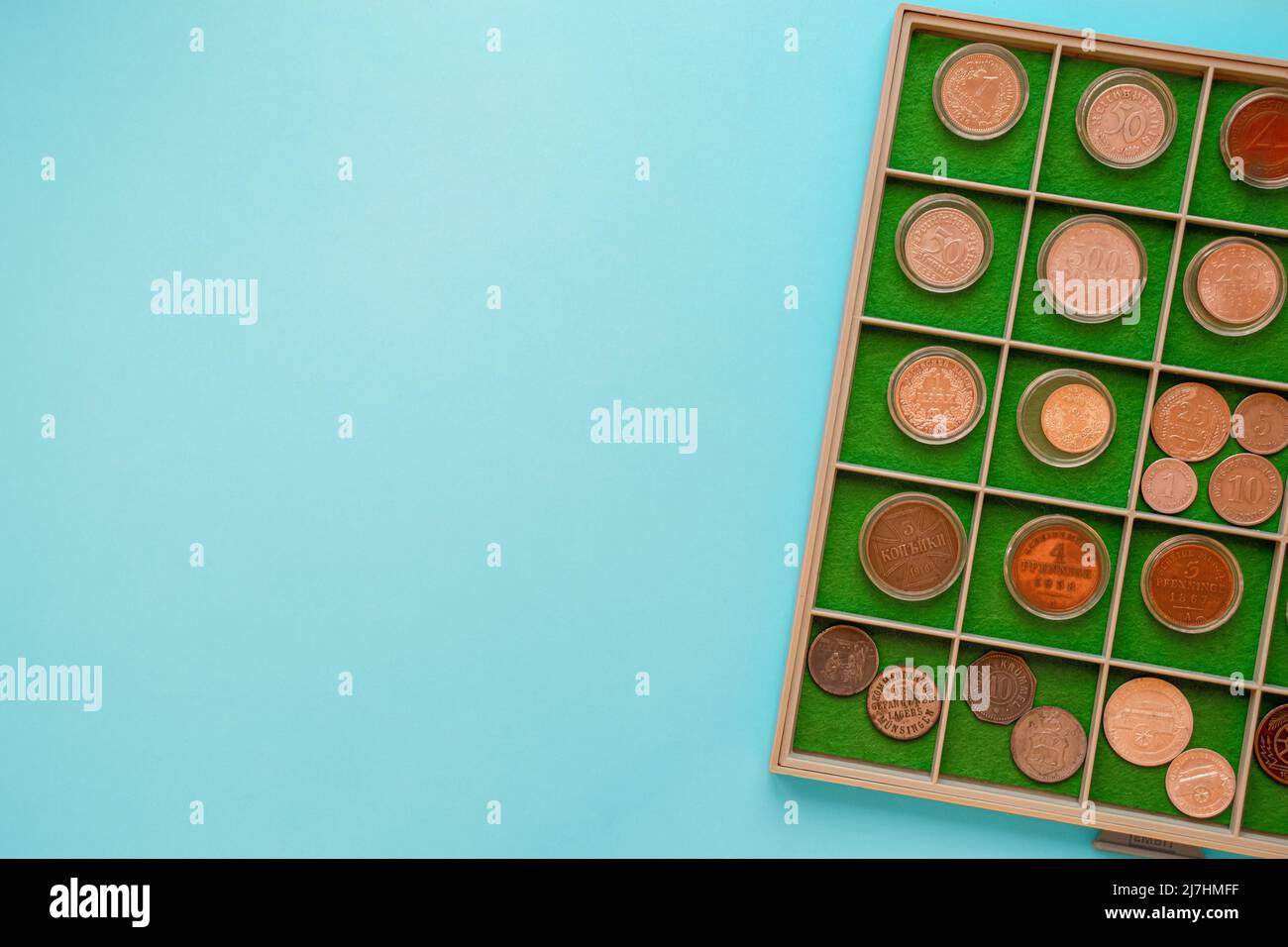 Numismatik Münzsammlung Album mit Kopieplatz. Draufsicht auf alte seltene Münzen auf blauem Hintergrund Stockfoto