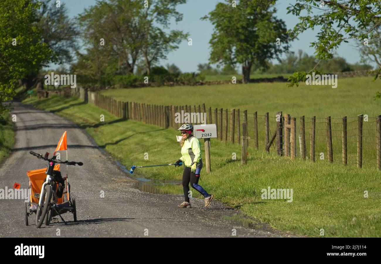 USA - 9. Mai 2022: Flora Hillman von Bloomfield nutzt ihr E-Fahrrad mit einem Call-Trailer im Schlepptau, um die Straßen im Westen von Loudoun zu säubern. Sie w Stockfoto