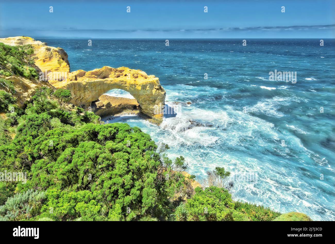 Malerischer Blick auf The Arch, Great Ocean Road, Australien, mit grünem Hintergrund vor dem Hintergrund der stürzenden Meereswellen Stockfoto